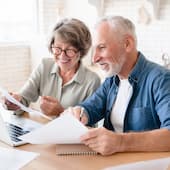 elderly couple smiling at their computer