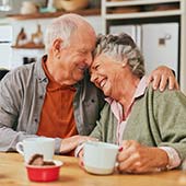 elderly couple smiling and hugging