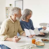 older couple looking at computer and paperwork